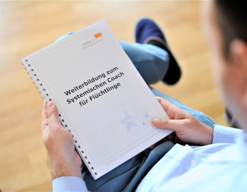 Teilnehmer*in erhält das Skript zur Weiterbildung zum Systemischen Coach für Flüchtlinge